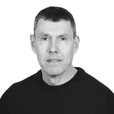 En porträttbild på Jens Ingolf, utbildningsledare på Affärshögskolan. Han är en man med kortklippt hår och en mörk tröja, fotograferad mot en vit bakgrund.